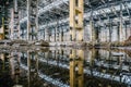 Abandoned industrial hall interior, celling and columns reflects in still waters