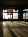 Abandoned industrial object with a torn banner on the wall. The sun is shining through the window. Beautiful shadows on the floor
