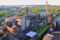 Abandoned ironworks factory with trees and city in the background