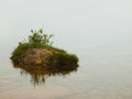 Abandoned island in lake. Big stone si sticking out from cold level.