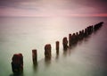 Abandoned jetty on sea sunset and sky reflection water. Royalty Free Stock Photo