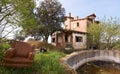 Abandoned leather armchair next to a ruined house and a pool without water Royalty Free Stock Photo