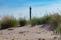 Abandoned lighthouse `Kiipsaare tuletorn` on Baltic Sea. Green grass and spikelets. with yellow sand on blue sky Royalty Free Stock Photo