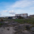 Abandoned lot with a pile of burned trash, discarded furniture and an old camper trailer Royalty Free Stock Photo