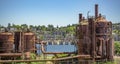 Abandoned machines and storage units in a gas industry at gas works park Seattle with homes behind Royalty Free Stock Photo