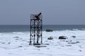 Abandoned marine tower on a snow in seashore Royalty Free Stock Photo