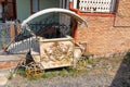 Rusty metal counter, in the form of a carriage, against the brick wall of the house