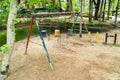 Abandoned metal swing in the park background. Damaged playground swing in the garden