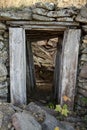 Abandoned mine entrance made of stone and wood. Lit from the inside.