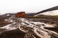 Abandoned norwegian whale hunter station rusty blubber tanks with muddy river in the foreground at Deception island, Antarctic