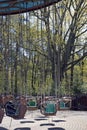 Abandoned nostalgic vintage whirligig merry go round in an amusement park with trees on the background on a sunny day