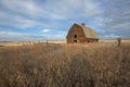 Abandoned old barn in grassy field in fall Royalty Free Stock Photo