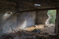 Abandoned old barn in a village interior with debris and sunlight falling through broken wall Royalty Free Stock Photo