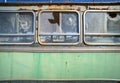 Abandoned old bus side view. Vintage pattern with peeled paint and broken glass Royalty Free Stock Photo