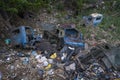 Abandoned old car cemetery junkyard in a garbage dump