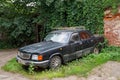 Abandoned old car GAZ-3102 `Volga` parked in the courtyard