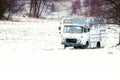 Abandoned old car in a snowy field near the forest. Vintage truck on the snow. Royalty Free Stock Photo