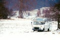 Abandoned old car in a snowy field near the forest. Vintage truck on the snow. Royalty Free Stock Photo