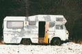 Abandoned old car in a snowy field near the forest. Royalty Free Stock Photo