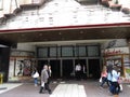 Abandoned old cinema with people passing by