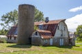 An abandoned old farm house with a tall brick silo and a big barn with rusted tin ceiling. Royalty Free Stock Photo