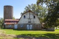 An abandoned old farm house with a tall brick silo and a big barn with rusted tin ceiling. Royalty Free Stock Photo