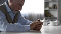 Abandoned old gentleman sitting at kitchen table, widower suffering loneliness Royalty Free Stock Photo