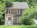 Abandoned Old House with Peeling Paint and Overgrown Yard and Trees Royalty Free Stock Photo