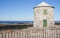 Abandoned old lighthouse with closed green door and windows on Atlantic ocean coast, Portugal. Lighthouse behind wooden fence. Royalty Free Stock Photo