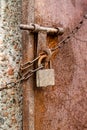 Abandoned old rustic lock with a chain on a metal door close up shot Royalty Free Stock Photo