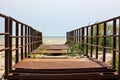 Abandoned old rusty bridge leading into the sea Royalty Free Stock Photo