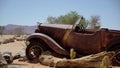 Abandoned old rusty car. Body of a retro car in the sands. Desert in Namibia. Royalty Free Stock Photo