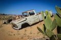 Abandoned old rusty cars in the desert of Namibia surrounded by cactus near the Namib-Naukluft National Park