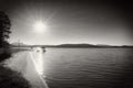 Abandoned old paddle boat stuck on sand of beach. Wavy water level, island on horizon