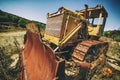 An abandoned old tractor with a bucket on a stone quarry. Old tractor in the field Royalty Free Stock Photo