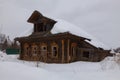 Abandoned old wooden rural house with a roof covered with snow, Russia Royalty Free Stock Photo