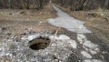 An abandoned open manhole with sticks sticking out of it. Close-up