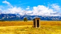 An abandoned Outhouse at Mormon Row with in the background cloud covered Peaks of the Grand Tetons In Grand Tetons National Park Royalty Free Stock Photo