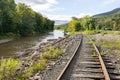 Abandoned, overgrown railroad train tracks along a rural river repurposed as trails for rail bikes in the Catskill Mountains of Ne