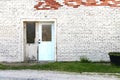 Abandoned painted white brick store doorway with exposed red brick Royalty Free Stock Photo