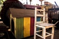 Abandoned pile of paraphernalia chairs, tractor, vibrant colored dog house and more at a shed
