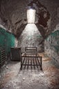 Abandoned prison cell room with old rusty bed frame and peeling walls