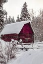 Abandoned red barn in winter scene covered in snow Royalty Free Stock Photo