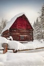 Abandoned red barn in winter scene covered in snow Royalty Free Stock Photo