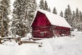 Abandoned red barn in winter scene covered in snow Royalty Free Stock Photo