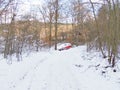 Abandoned red car forest in snow crashed ditched hazard left behind vehicle