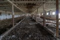 Abandoned ruined barn cowshed inside view. The old abandoned barn with the remains of feeders. barn from inside with low light Royalty Free Stock Photo