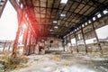 Abandoned ruined industrial warehouse or factory building inside, corridor view with ruins and pitted roof Royalty Free Stock Photo