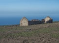 Abandoned ruins of farm house at flat plateau on top of La Merica mountain with cacti, stones and sea view. valle Gran