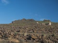 Abandoned ruins of farm house at flat plateau on top of La Merica mountain with cacti, stones and sea view. valle Gran